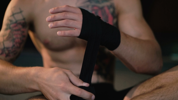Free Fighter Wraps His Hands with Black Hand Wrap Before the Fight Training alt