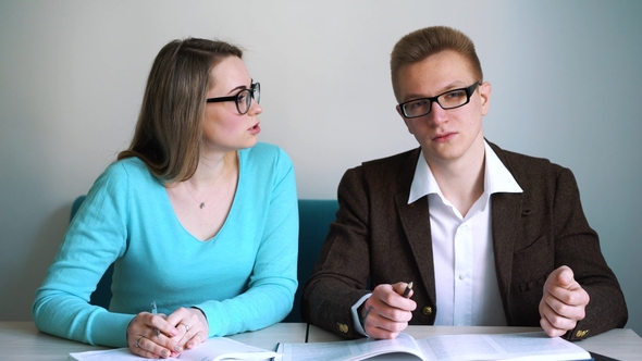 Man and Girl Students Sitting at the Table, Answer Questions