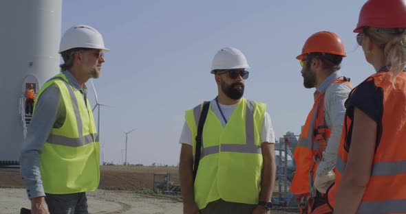 Engineers Inspecting Construction Site Near Windmill alt