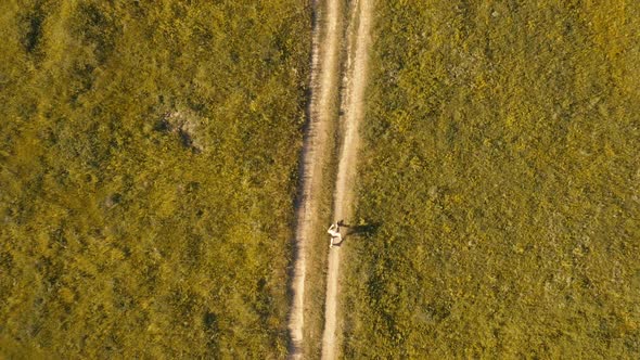 Man Runner Running on Coutryside Road. Top View Aerial Dron Footage.