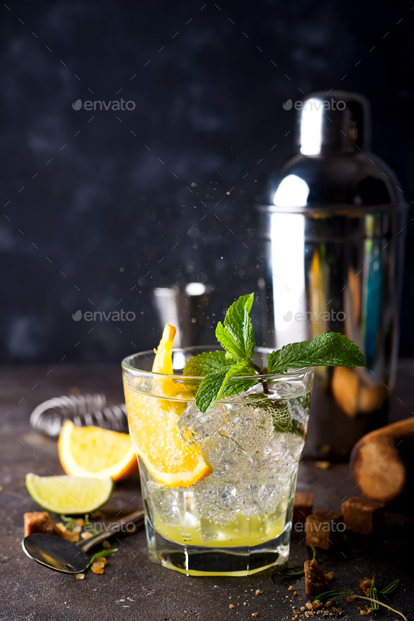 Orange cocktail with ice, leaf of mint and orange slice. Stock Photo by lyulkamazur