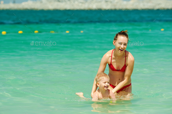 Happy mother teaching her little son to swim Stock Photo by haveseen