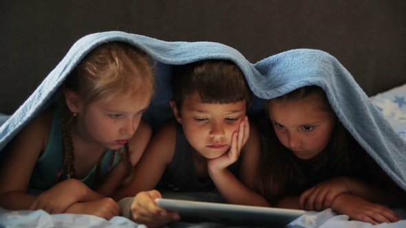 Children Look Cartoon on the Tablet alt