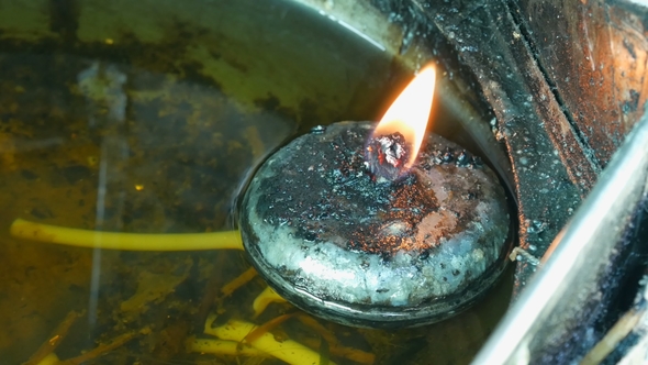 Round Iron Candle with Eternal Fire in Special House. Buddhist Offering To the Gods in the Form of alt