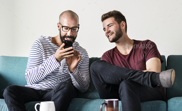 Two men on couch chilling and playing with mobile Stock Photo by Rawpixel