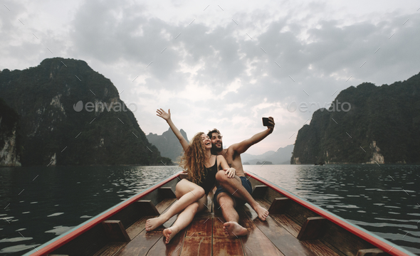 Couple taking selfie on a longtail boat - Stock Photo - Images
