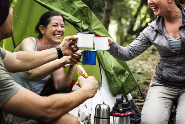 Group of friends camping in the forest - Stock Photo - Images