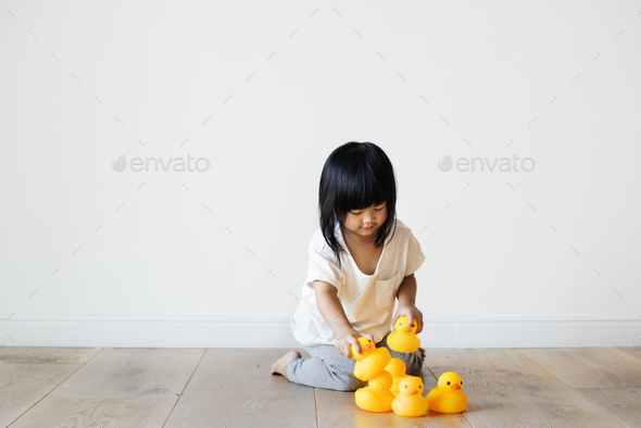 Young Asian girl playing alone - Stock Photo - Images