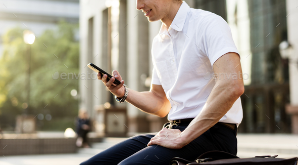 Young adult man checking his smartphone - Stock Photo - Images