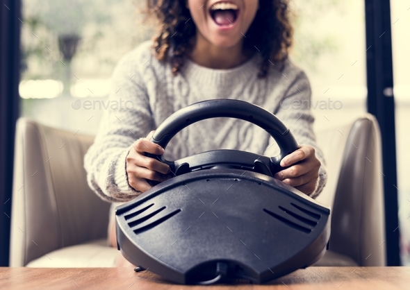 Woman playing a car racing vdo game - Stock Photo - Images