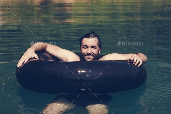 Happy man floating around in the water - Stock Photo - Images