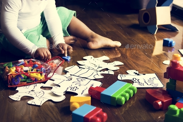 African descent kid enjoying puzzles on wooden floor Stock Photo by Rawpixel