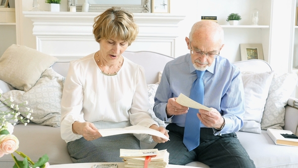 Portrait of Happy Attractive Senior Couple Reading the Old Letters