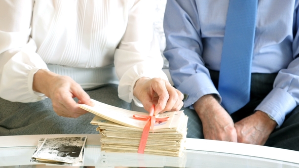 Portrait of Happy Attractive Senior Couple Reading the Old Letters alt