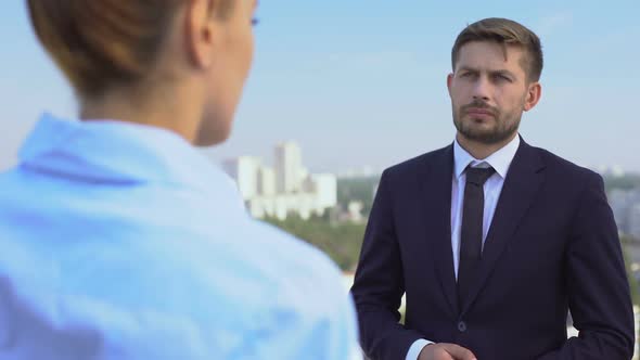 Worried Businessman Listening Female Colleague Outdoors Discussing Work Trouble