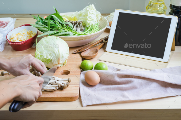 Young woman using her touchpad in the kitchen - Stock Photo - Images