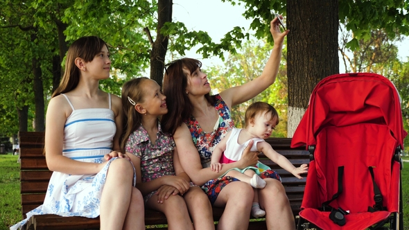 Young Mother Is Photographed with Her Children on Phone While Sitting ...