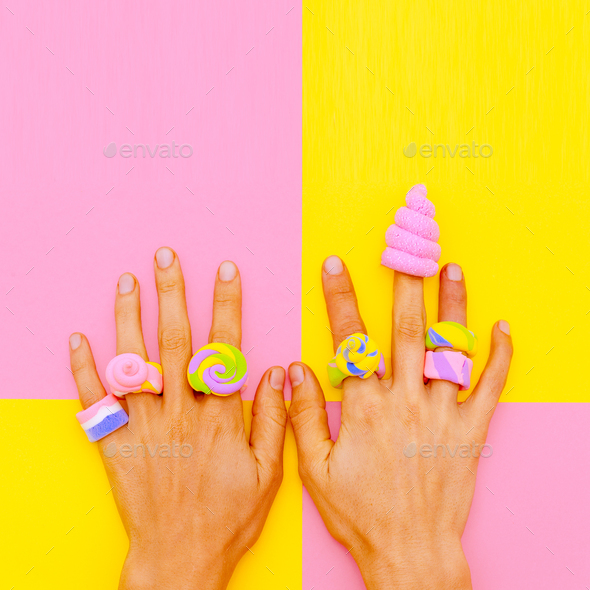 Hands in candy accessories. Minimal sweet mood. Vanilla fashion