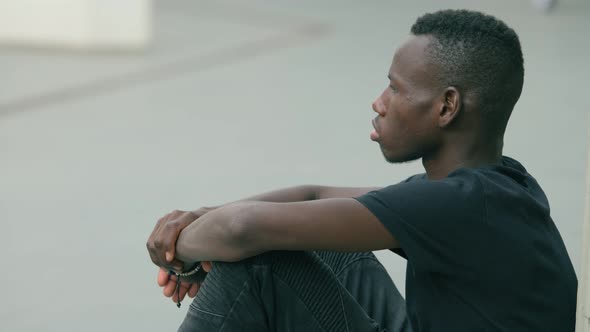 Lonely depressed young african migrant alone in the city alt