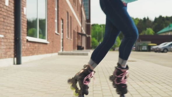 Young Woman Eenjoys Rollerblading on a City Street