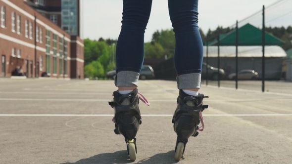 Female Legs in Roller Skates on Asphalt in City alt