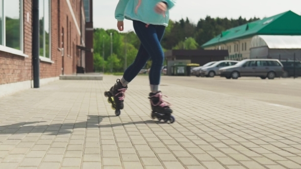 Women's Legs Riding on Roller Skates on City Street