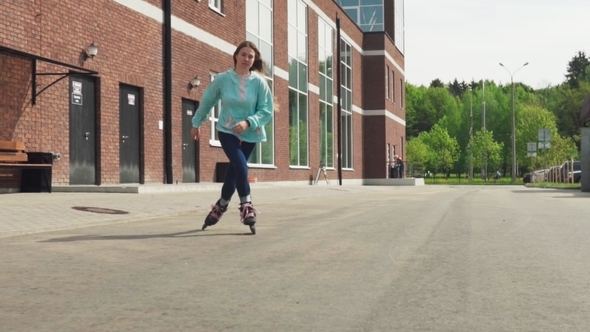 Happy Young Girl Riding on Roller Skates on Asphalt Road in City