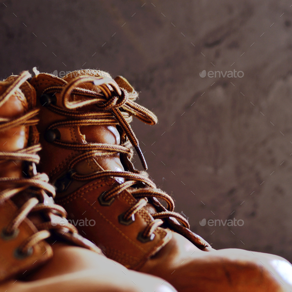Yellow leather used work boots on concrete background closeup. P Stock Photo by d_mikh