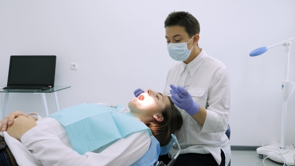 Dentist Take Filling Instrument To Exam Teeth. alt