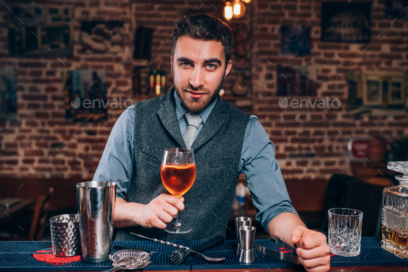 expert bartender presenting Signature drink at local pub, bar or restaurant Stock Photo by stockcentral