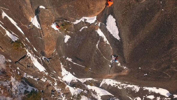 Aerial View of a Rock Climber Climbing a Steep Cliffs During a Sunny Winter Day.