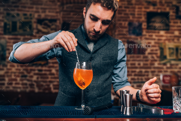Portrait of professional bartender preparing cocktail, refreshing alcoholic drink in nightclub Stock Photo by stockcentral