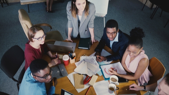Top View Teamwork at Development Company Office. Multiethnic Creative Team Discussing Real Estate alt