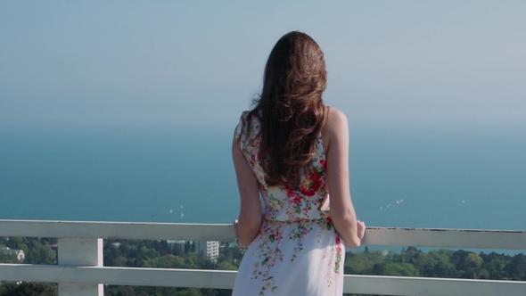 Beautiful Caucasian Girl on a Terrace Over the City Against the Sea