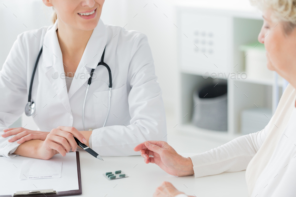 Doctor prescribing medication to patient Stock Photo by bialasiewicz