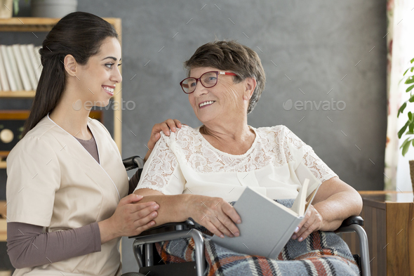 Woman in wheelchair with nurse - Stock Photo - Images