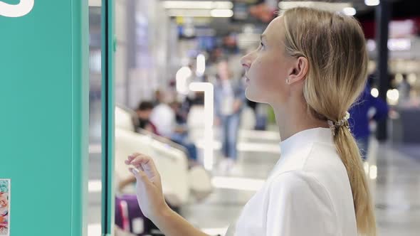 Young Woman Touching Sensitive Screen in Shopping Mall alt