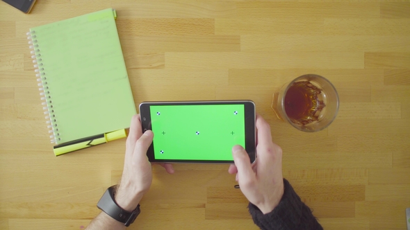 Man Playing a Game on Tablet with Green Screen