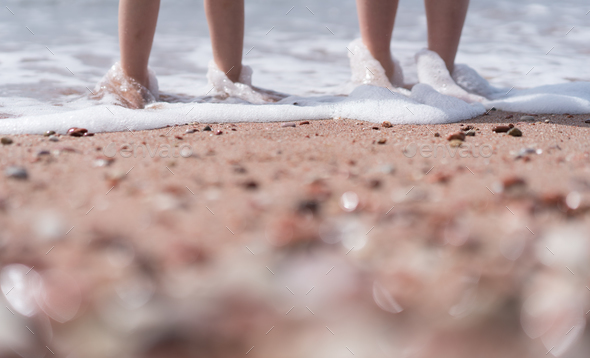 Kids feet in sea water on the beach - Stock Photo - Images
