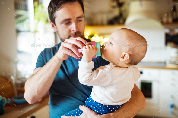 Father with a baby girl at home. - Stock Photo - Images