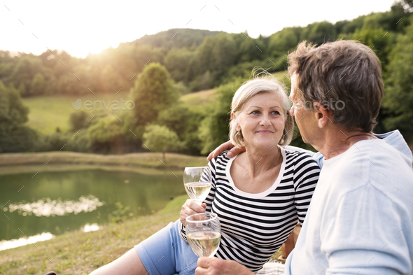 Senior couple at the lake having a picnic. Stock Photo by halfpoint