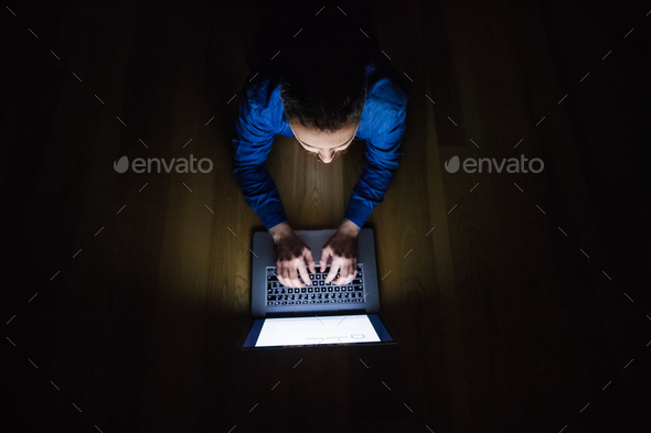 A man working on a laptop at home at night. - Stock Photo - Images