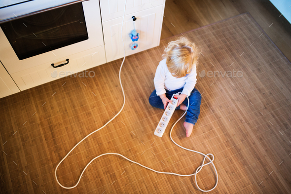 Toddler boy in dangerous situation at home. Child safety concept. Stock Photo by halfpoint