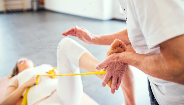 Unrecognizable senior physiotherapist working with a female patient. - Stock Photo - Images