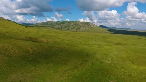 Green Meadows, Hills in the Distance and Cloudy Sky in the Republic of Khakassia