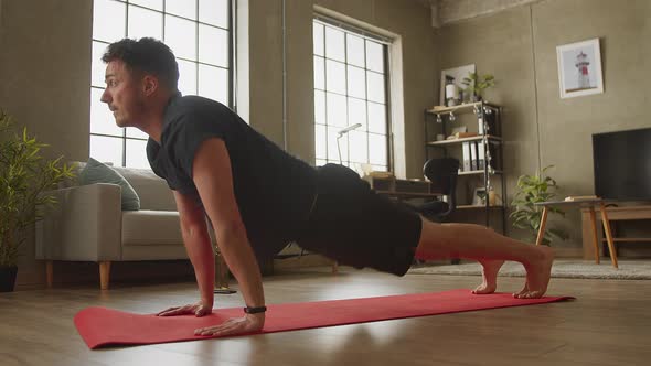 Young Man Doing Yoga at Home in Living Room alt