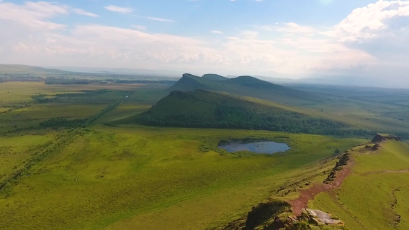 Aerial View of the Mountain Range Sunduki, Green Fields Sky Before the Storm in the Republic of