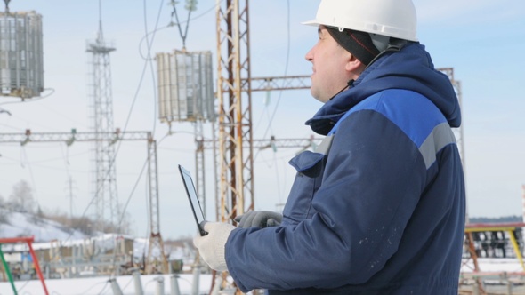 Engineer With Portable Computer at Electric Power Station