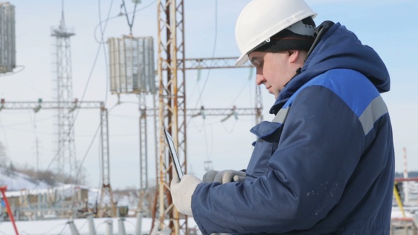 Engineer With Portable Computer at Electric Power Station