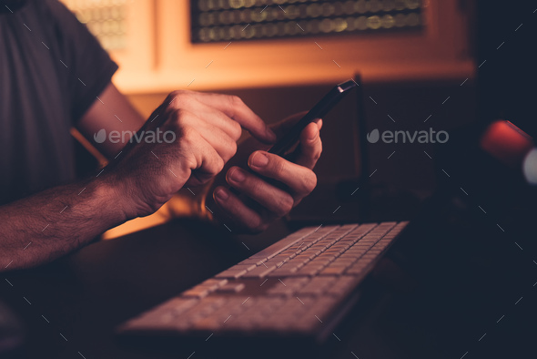 Man with smart phone in home office interior - Stock Photo - Images